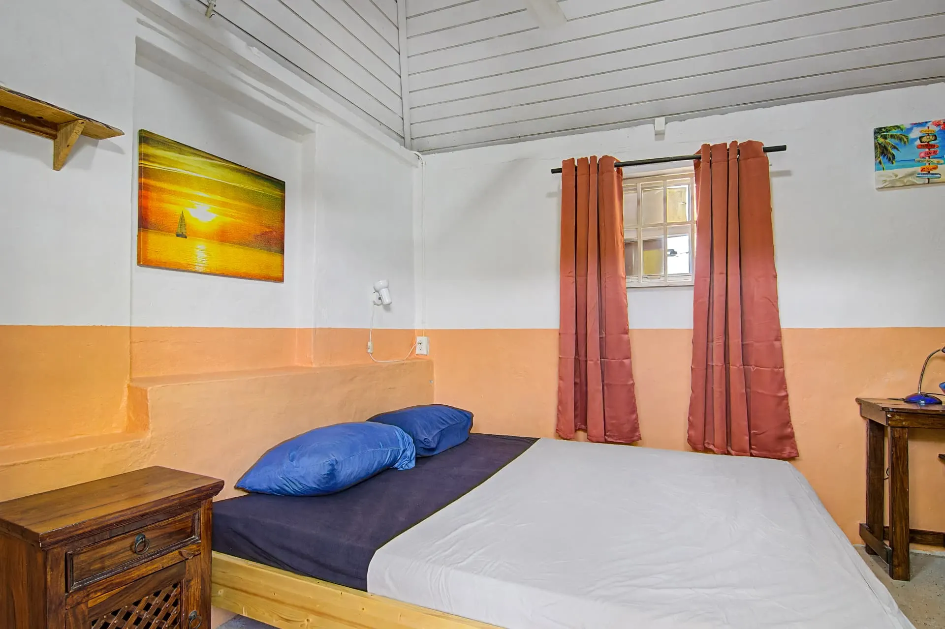 Casa 2 private studio bedroom with double bed and sunset artwork