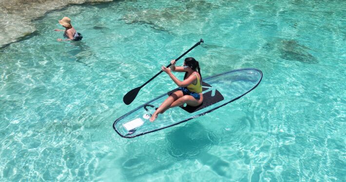 Woman paddleboarding on clear turquoise water in Curaçao