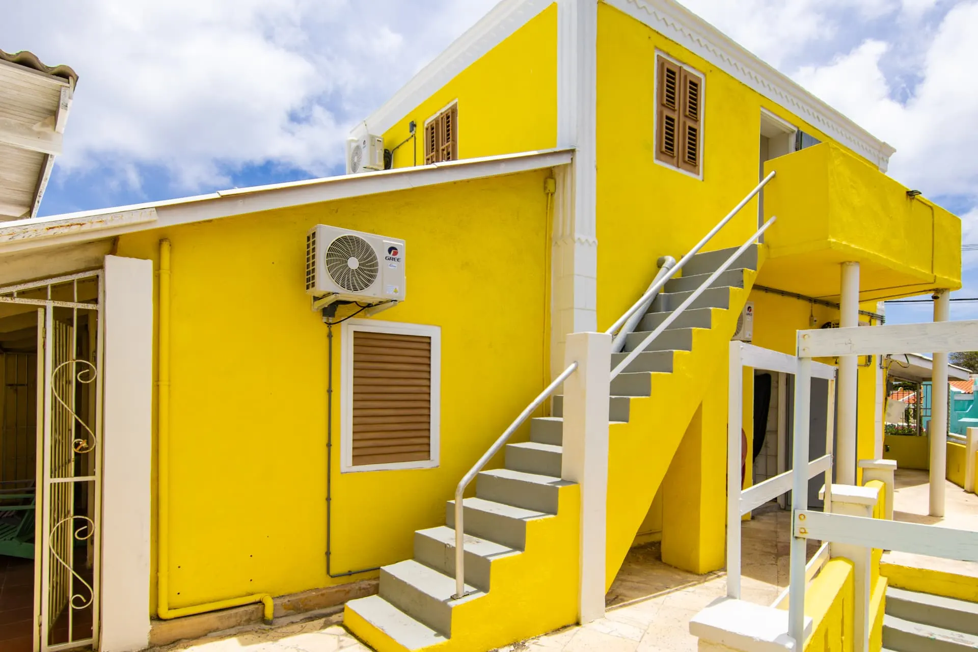 Casa 2 exterior stairs and bright yellow facade
