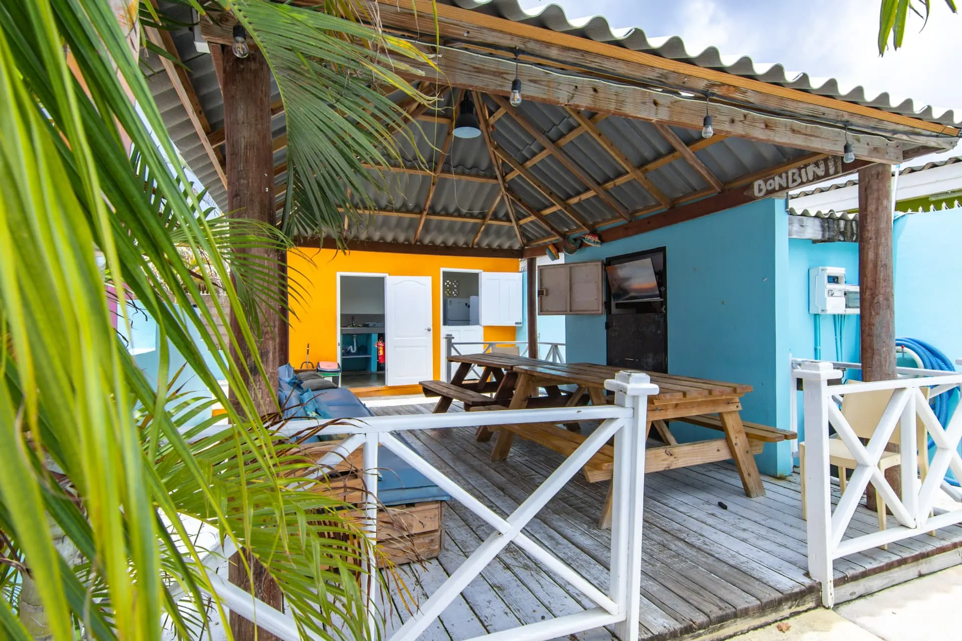 Casa 7 outdoor lounge with wooden deck and palm trees
